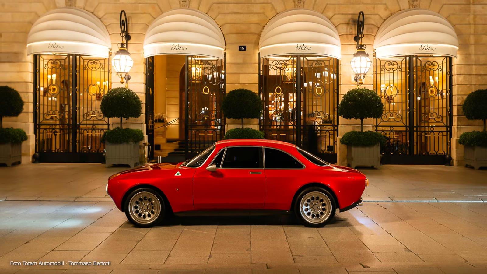 A red Totem GT in front of the entrance of a luxury hotel.